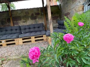 a patio with a black couch and pink flowers at Gästehaus Bonaforth in Hannoversch Münden
