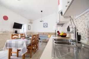 Il comprend une cuisine et un salon avec une table et des chaises. dans l'établissement Altura Beach & Village Escape, à Altura