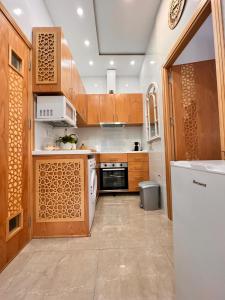 uma cozinha com armários de madeira e um frigorífico branco em Casa Riad Amor Marrakech en Lo Pagan em San Pedro del Pinatar