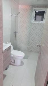 La salle de bains blanche est pourvue de toilettes et d'une fenêtre. dans l'établissement Punta Cana, à Punta Cana