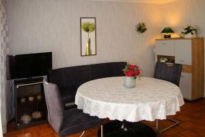 een woonkamer met een tafel met een vaas met bloemen bij Gästezimmer Wagner in Hannoversch Münden