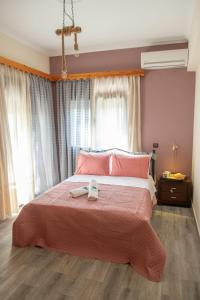 a bedroom with a large bed with pink sheets at Villa Olive and Sea in Mytilini