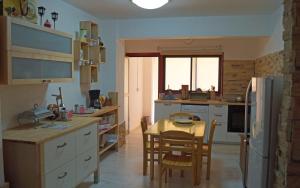 a kitchen with a table and chairs and a kitchen with a refrigerator at Destalo Court Larnaca Apartment in Larnaka