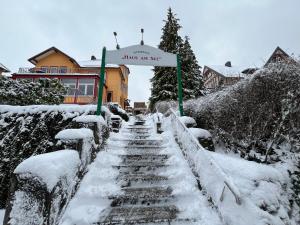 eine schneebedeckte Treppe vor einem Schild in der Unterkunft Haus am See in Bad Sachsa