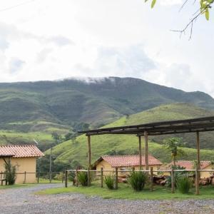 vistas a una montaña desde una granja con un edificio en Refúgio Pé da Serra - Chalés, en São Roque de Minas