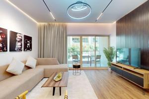 een woonkamer met een bank en een tv bij Al Arta 3 - Vacationer in Dubai