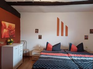 een slaapkamer met een bed met blauwe en rode kussens bij Pension Altes Haus in Hannoversch Münden