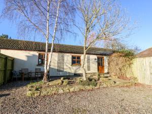 a white cottage with trees in front of it at Ivy Cottage in Richmond