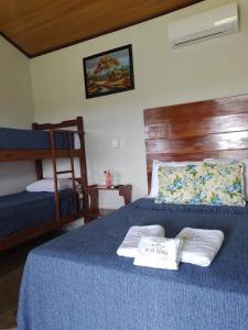 a bedroom with a blue bed with two towels on it at Refúgio Pé da Serra - Chalés in São Roque de Minas