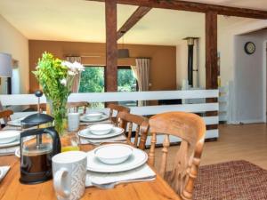 a wooden table with chairs and a dining room at 3 bed in Bude TRVVV in Poughill