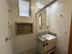 a bathroom with a sink and a mirror at Praia & Pé na areia Itaparica in Vila Velha