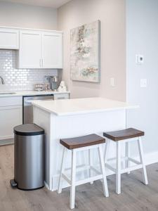 une cuisine avec un comptoir blanc et deux tabourets dans l'établissement New Construction New Furnishings Luxury Unit, à Evansville