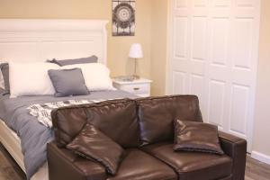 um sofá de couro numa sala de estar com uma cama em Enchanting suite nestled in quaint Santa Clarita em Santa Clarita