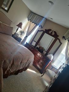 1 dormitorio con cama, tocador y espejo en Chiky Sanctuary en Raleigh