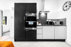 a black and white kitchen with a stove and appliances at New Luxury Apartment - Parking - Netflix - Wifi - Apt 49G in Sleightholme