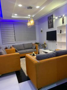 - un salon avec deux canapés et une télévision dans l'établissement Timba belleVilla, à Cotonou
