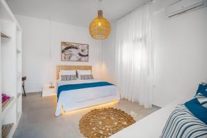 una camera bianca con un letto e un tappeto di SELANA Suites Chora a Serifos Chora