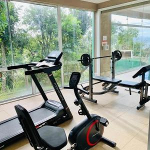 a gym with several exercise bikes and a large window at Silveira Eco Village Residence in Garopaba
