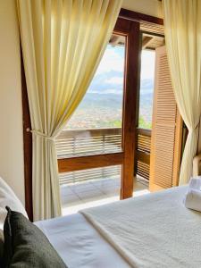 1 dormitorio con cama y ventana grande en Silveira Eco Village Residence en Garopaba