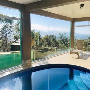 uma piscina numa casa com uma grande janela em Silveira Eco Village Residence em Garopaba
