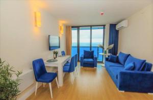 a living room with a blue couch and a table and chairs at ORBI CITY -aparthotel in batumi in Batumi