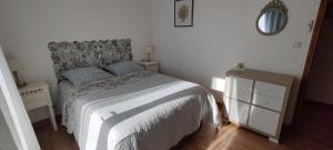 um quarto com uma cama, uma cómoda e um espelho em Les Chevêches em Milhac-dʼAuberoche