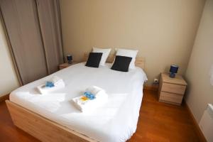 a bedroom with a large white bed with two pillows at La villa Fontaine in Moussy