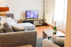 a living room with a couch and a bottle of champagne at La villa Fontaine in Moussy