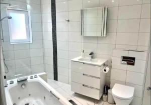 een badkamer met een bad, een toilet en een wastafel bij Gorgeous One Bedroom Apartment with Jacuzzi bath in Hither Green