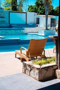 a wicker chair sitting next to a swimming pool at Residencial Del Golf in La Lima
