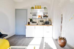 una cocina con armarios blancos y una silla amarilla en 1bd Presidential Neighbor Retreat, Ac, Kitchen, en Sofía