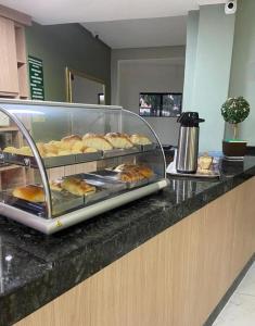 a bakery counter with a display case of pastries at Caldas Novas - Araras Apart Service in Caldas Novas