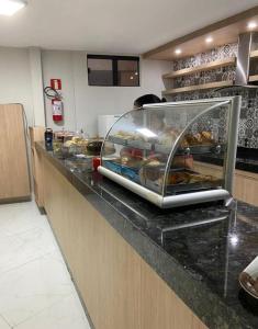 a bakery counter with a display of food on it at Caldas Novas - Araras Apart Service in Caldas Novas