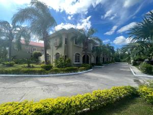 a house with palm trees and a driveway at Residencial Del Golf in La Lima