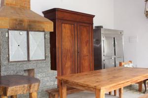 a wooden cabinet next to a table and a refrigerator at Fazenda Dos Coqueiros-Bananal-SP in Bananal