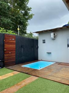 un patio trasero con piscina en una terraza de madera en Casa alter oficial, en Alter do Chao