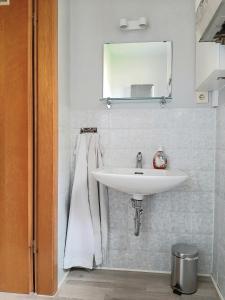 uma casa de banho com um lavatório branco e um espelho. em Art-Apartment III em Bad Karlshafen