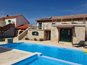 a villa with a swimming pool in front of a house at VILLA KUNTA in Donja Jagodnja