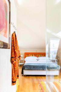 una camera con un letto e una coperta arancione di La Mansarda al mare Centro storico di Loano con GARAGE a Loano