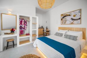 Un dormitorio con una cama azul y blanca y una mesa en SELANA Suites Chora, en Serifos Chora