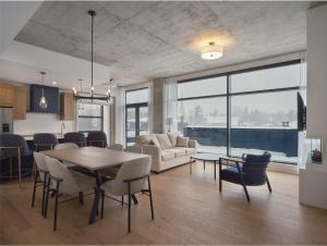 a dining room and living room with a table and chairs at Hôtel Expérience - Quartier Des Marinas in Magog-Orford