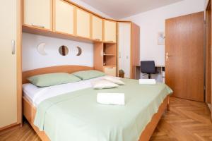 1 dormitorio con 1 cama blanca grande y armarios de madera en Apartment Anita, en Trogir
