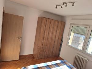 a bedroom with a wooden cabinet and a window at Temple saint sava in Dušanovac (historical)