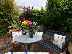 ein Tisch und Stühle mit einer Blumenvase drauf in der Unterkunft 2 bed in Brixham BX021 in Brixham