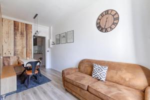 ein Wohnzimmer mit einem Sofa und einem Tisch in der Unterkunft Magnifique appartement Porte d'Orléans in Montrouge