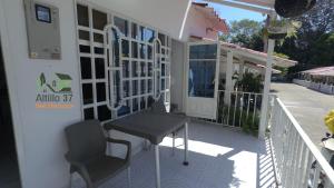 a balcony with a table and chairs on a house at Melgar-Tolima-Apartaestudio in Melgar