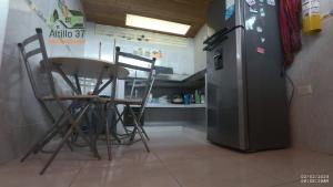a kitchen with a table and chairs next to a refrigerator at Melgar-Tolima-Apartaestudio in Melgar