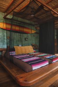a bed with colorful blankets on it in a room at Frutas y Verduras in Puerto Escondido