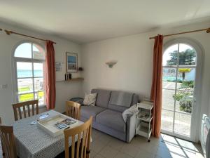 een woonkamer met een bank en een tafel bij Superbe appartement les pieds dans l'eau ! in La Tranche-sur-Mer