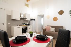 cocina y sala de estar con mesa y copas de vino en Isonzo House, en Bari